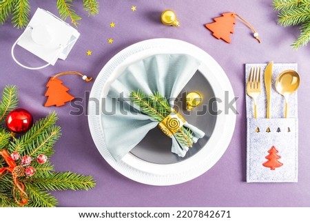 beautiful top view of the festive New Year's serving on the gray background of the tablecloth. fan folded napkin on plates. Christmas decorations