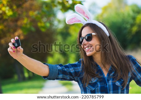 woman taking selfie, wearing bunny ears