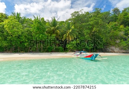 Traditional wooden fishing boats and beautiful Indonesian beach.  Beautiful indonesian beach Royalty-Free Stock Photo #2207874215