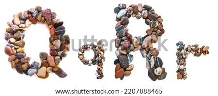 A letter of smooth stones on a white isolated background. Of the river stones lined with a letter, detailing, close-up. Selective focus.