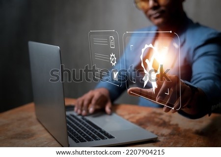 concept of quality development Business man wearing suit working on laptop with signs of top service, certification, quality control. have checked the standard guarantee