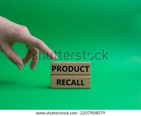 Product recall symbol. Concept words Product recall on wooden blocks. Beautiful green background. Businessman hand. Business and Product recall concept. Copy space.