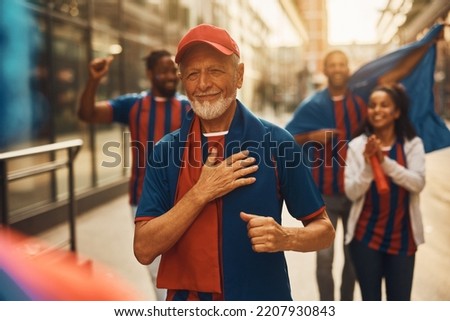 Senior sports fan feeling proud while going on football match and wearing his favorite team's jersey. Royalty-Free Stock Photo #2207930843
