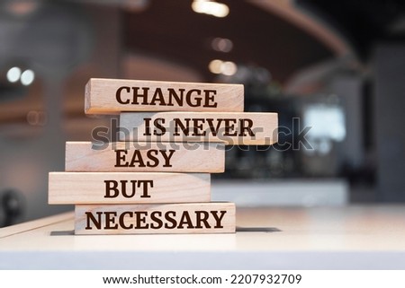 Wooden blocks with words 'Change Is Never Easy But Necessary'. Royalty-Free Stock Photo #2207932709