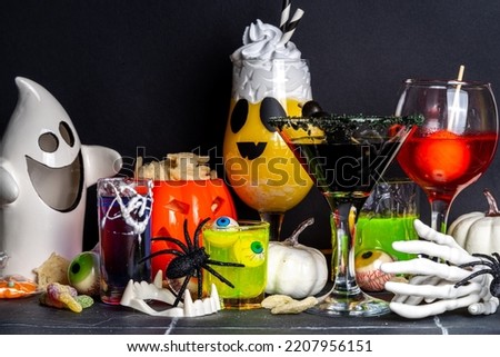 Halloween party bar festive drink, set various colorful alcohol, non-alcohol cocktails, drinks with halloween characters costumes hands, holiday decor and symbols