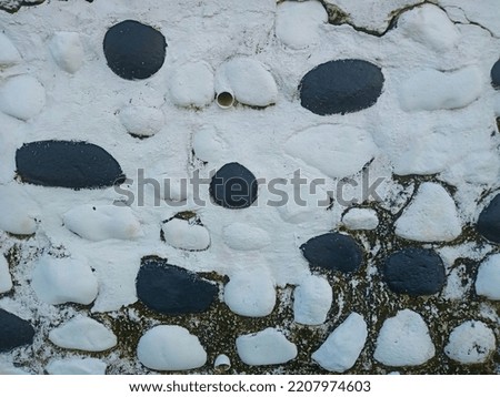 Concrete wall with black and white stained stone