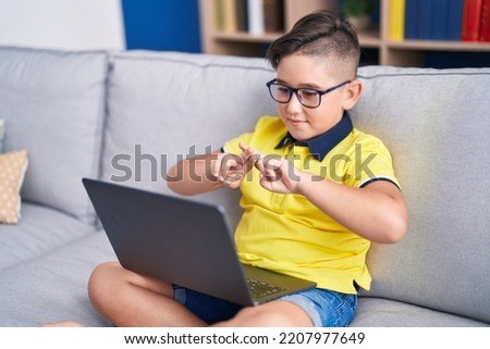 Adorable hispanic boy having video call communicate with sign deaf language at home