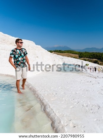 Natural travertine pools and terraces in Pamukkale. Cotton castle in southwestern Turkey,young men watching sunset at the natural pool Pamukkale Turkey