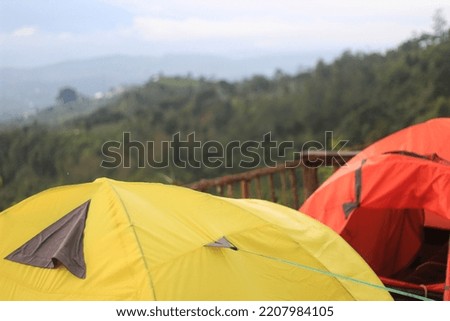 yellow tent and orange tent with mountain background