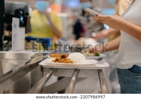 Lady paying with mobile phone in shopping mall