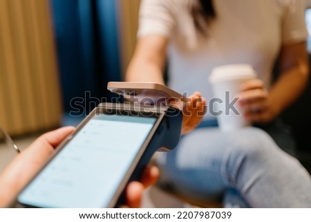 woman pay with smartphone in shopping mall