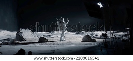 WIDE Male actor in astronaut suit making selfie on a Moon Lunar movie shooting set