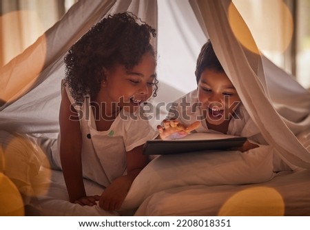 Children, tablet and night streaming online for movies, cartoon or educational games before bedtime in a blanket fort with a fun app. Excited boy and girl kid sharing, reading and internet addiction