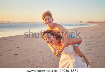 Mother, child and piggy back on beach on summer holiday walking in sea sand. Woman from Australia with son at the ocean. Mom, happy kid and sunset, family time with water, freedom and fun on vacation Royalty-Free Stock Photo #2208018589