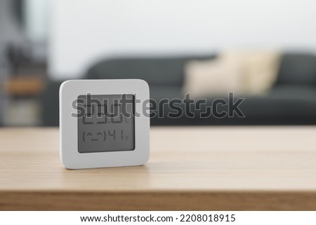 Digital hygrometer with thermometer on wooden table indoors. Space for text Royalty-Free Stock Photo #2208018915