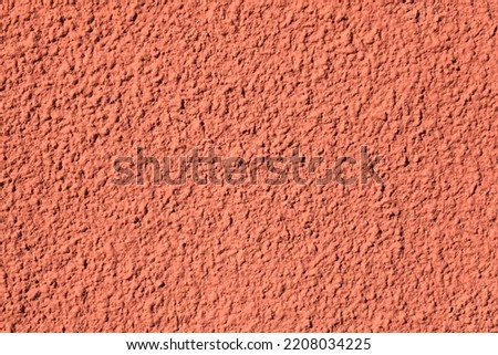Pink wall, texture, background. Relief surface. Plastered building wall, painted with water-based pink paint. Decorated surface with blurry chaotic pattern. Embossed patterns