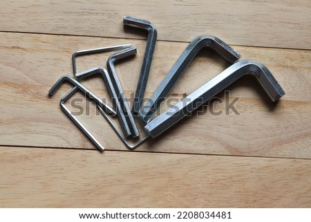 Metal hexagon wrench many size hardware tools isolated on wooden background closeup.
