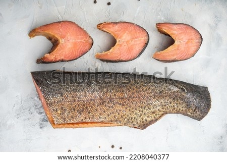 hot smoked fish with cut pieces lie on a light background with pepper
