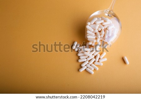 white medicine capsules on orange background	