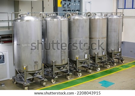 Stainless vertical steel tanks with pressure meter in equipment tank chemical cellar at the with scrolling wheel stainless steel tanks cleaning and treatment at shampoo plant