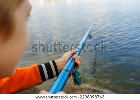 close-up of the hand of a boy who holds a fishing rod and fishes