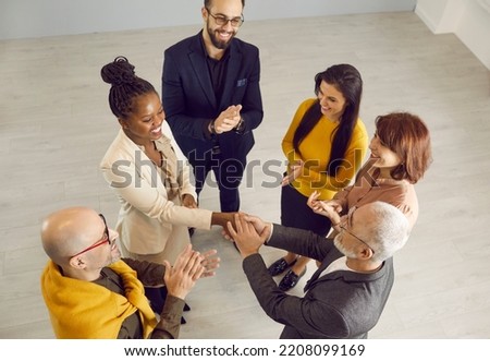 Top view of businessman handshake ethnic female partner congratulate with work success. Young African American woman get acknowledgement from colleagues. Boss greeting coworker with promotion. Royalty-Free Stock Photo #2208099169