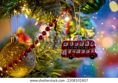 A little, red double decker bus from London as a christmas ornament on a illuminated tree with selective focus Royalty-Free Stock Photo #2208101807