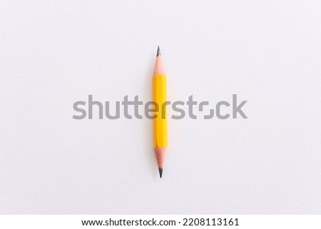 Top view image of pencil sharpened on both sides over white textured paper
