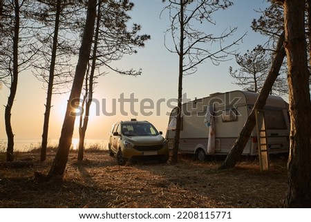 Beautiful sunrise in the camping. Camping van in the forest