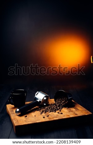 Portafilter and coffee beans with a cup on a wooden board