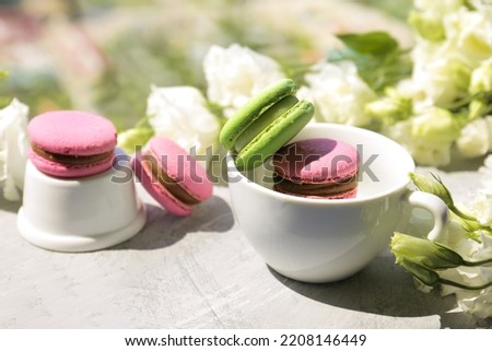 Eustoma and macaroon on a light background. Delicate composition, postcard, congratulations, good morning. Delicious dessert.