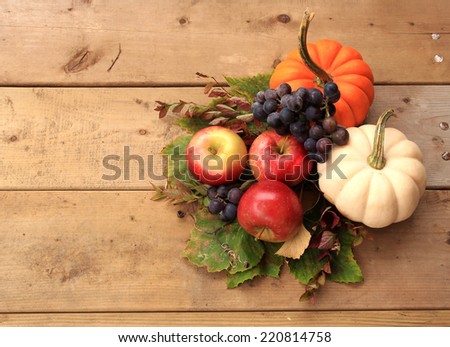 Autumn and Thanksgiving concept. Seasonal fruit and pumpkins on wood background.