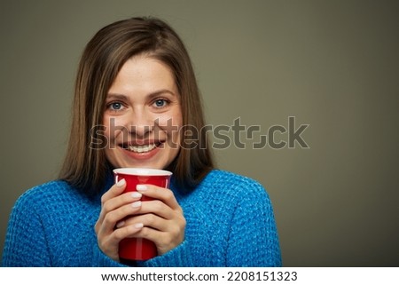 Woman warming with hot drink. Isolated portrait.