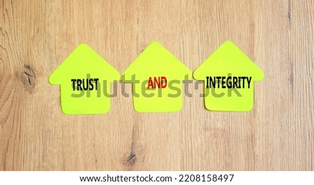 Trust and integrity symbol. Concept words Trust and integrity on papers on wooden clothespins. Beautiful wooden background. Business, psychological and trust and integrity concept. Copy space.