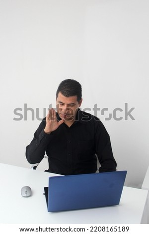Latino adult man speaks Mexican sign language with a deaf person through a laptop in a video call