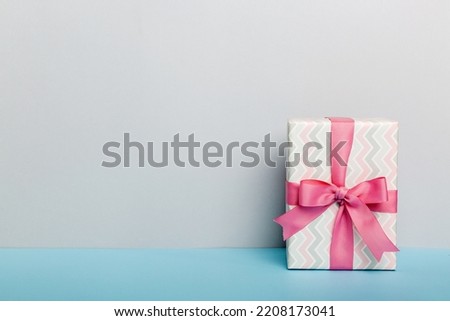 holiday paper present tied pink ribbon bow top view with copy space. Flat lay holiday background. Birthday or christmas present. Christmas gift box concept with copy space.