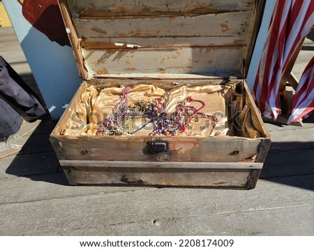 An open old chest with pretend treasure sitting inside of it.