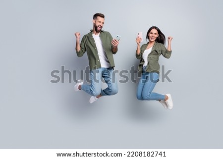 Full size photo of excited lady guy blogging jump fists up use smart device discount isolated over grey color background