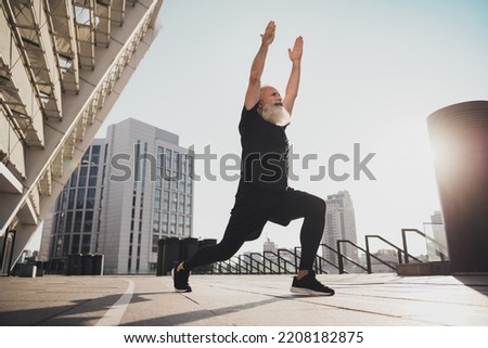 Photo of sportive energetic bearded grandpa man raise hands make stretching squats urban town outdoors