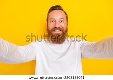 Photo of satisfied glad person take selfie beaming smile isolated on yellow color background