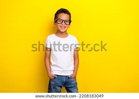 Photo of cool small boy wear white t-shirt eyewear jeans isolated on yellow color background Royalty-Free Stock Photo #2208183049