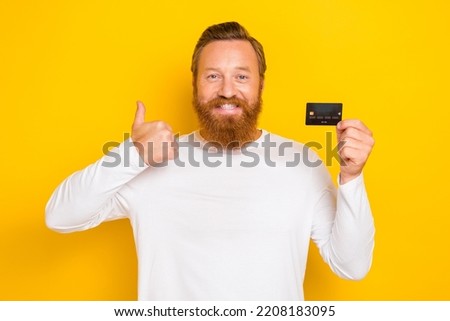 Photo of positive stylish man bank client arm hold plastic card satisfied service good job isolated on yellow color background
