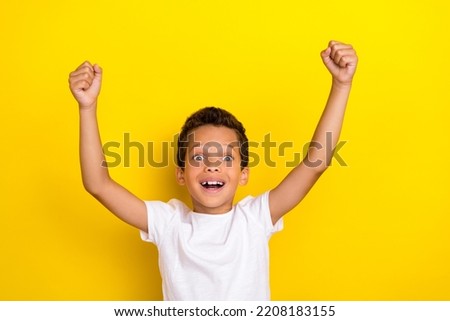 Photo of satisfied boy football fan celebrate rejoice scream yes support favorite team hand arm raise isolated on yellow color background Royalty-Free Stock Photo #2208183155