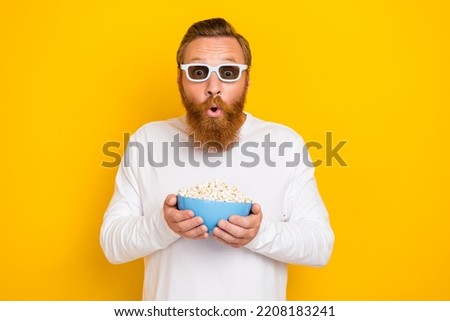 Photo of cool beard red hair man hold popcorn watch film wear eyewear white shirt isolated on yellow color background