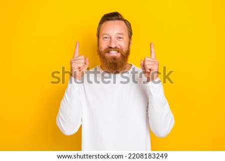 Photo portrait of nice cheerful young guy toothy smile point up empty space dressed trendy white outfit isolated on yellow color background