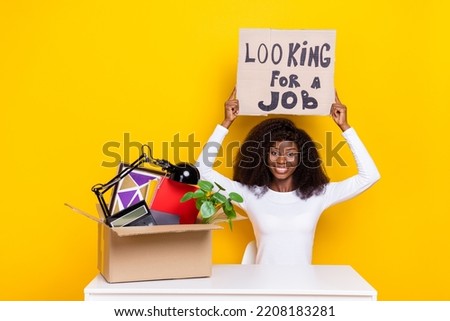 Photo of cheerful nice person arms hold paper looking job banner board isolated on yellow color background