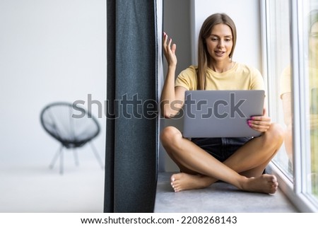 Young pretty woman have video call on laptop from home office Workplace on the windowsill. Concept of female business, career, online shopping.