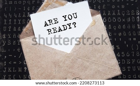 ARE YOU READY. text on white paper on vintage envelope on dark background. View from above. Marketing concept.