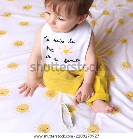 A baby wearing a bib saying that he's the little sun of the family in French. Royalty-Free Stock Photo #2208279927