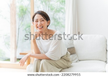 Middle-aged Asian woman relaxing at home Royalty-Free Stock Photo #2208279955